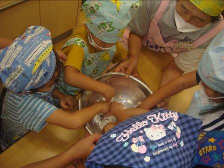 幼稚園児とヘルスメイトが一緒にお団子をこねている写真