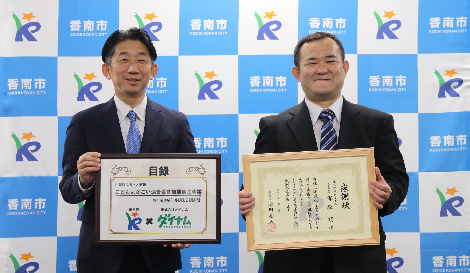 画像左に目録を持った濱田市長、右に感謝状を持った株式会社ダイナム経営企画部永田様