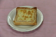 食パンに、ツナ缶のツナ、マヨネーズ、塩コショウを混ぜたものとチーズを乗せて焼かれたトースターの写真