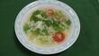 レタスやミニトマトが入れられ、鶏がらスープと塩、コショウなどで味付けされたスープの写真