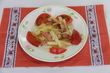 炒められた千切りのジャガイモとベーコンの上から、とろけるチーズを乗せて、トマトを添えた料理の写真