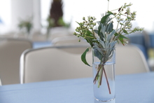 テーブルの上に白い草花が1セット飾られている写真。