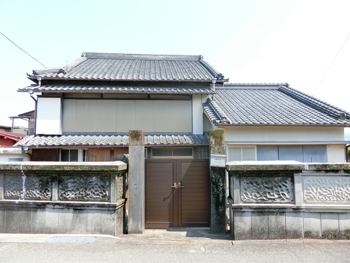茶色の門扉の奥に建っている空き家（日本家屋）全体の写真