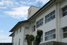 白い外壁の学校の校舎の一部を写した写真