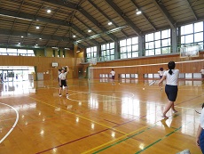 体育館でバレーボールをする女子児童の写真