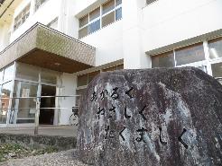 校舎横にある「あかるく やさしく たくましく」と刻まれた石の写真